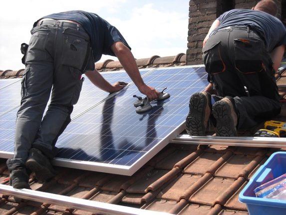 Homme posant un panneau solaire