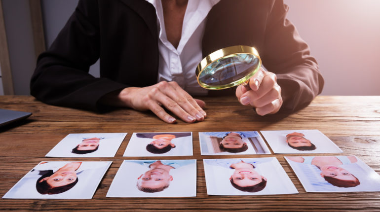 Une personne qui cherche minutieusement un bon candidat dans une situation de pénurie de profils qualifiés