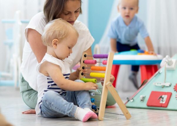 Femme qui fait jouer un enfant avec un jouet montessori