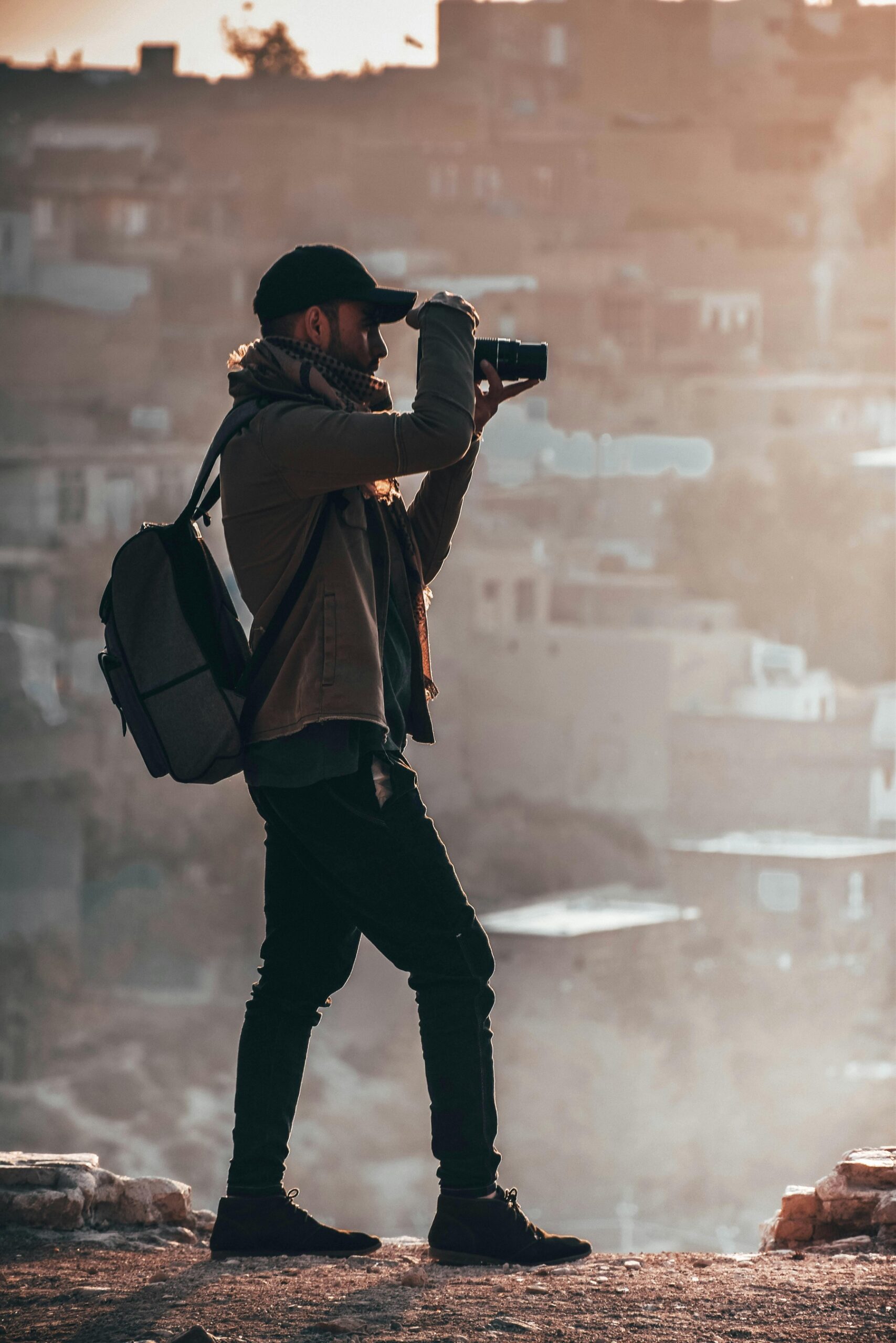 Photographe debout en extérieur, prenant une photo avec un appareil photo