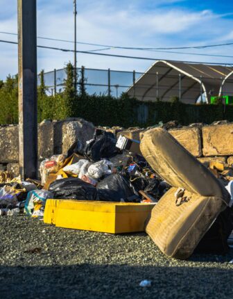 Tas d’encombrants et de sacs-poubelles abandonnés sur la voie publique, illustrant un dépôt sauvage.