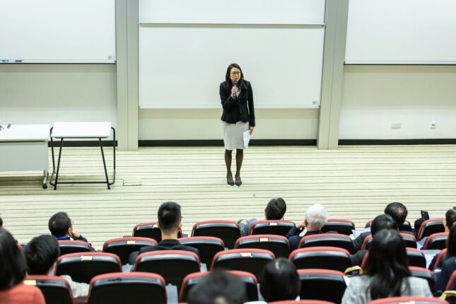 Conférencière parlant devant un public en amphithéâtre