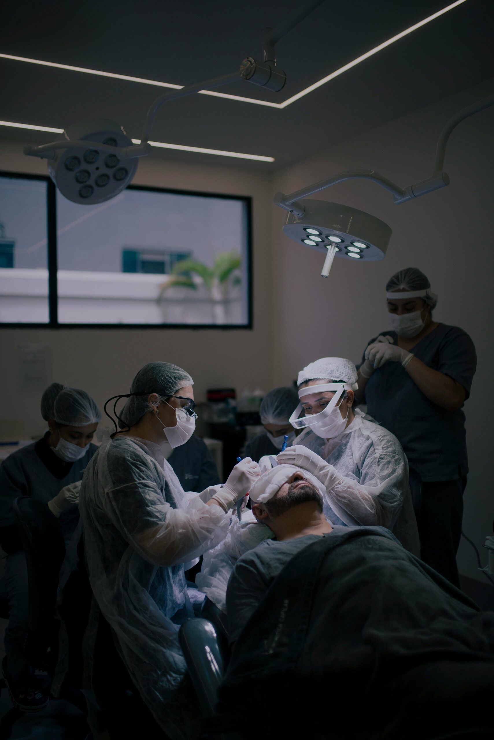Équipe médicale en train de réaliser une greffe de cheveux sur un patient.