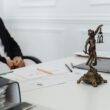 Bureau avec une statue de la justice et des documents juridiques.