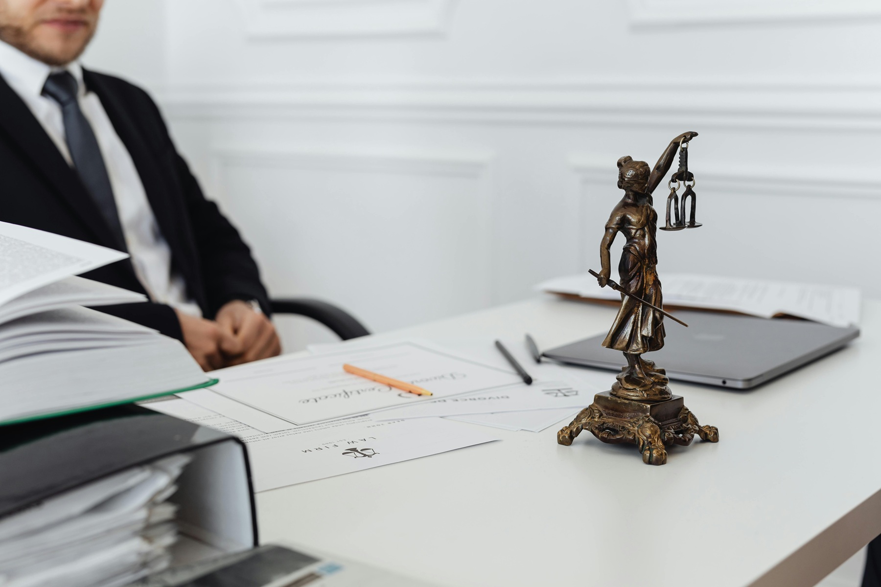Bureau avec une statue de la justice et des documents juridiques.