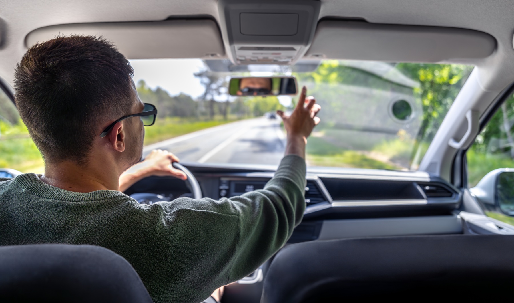 Homme vérifiant une voiture d’occasion pendant un essai de conduite.