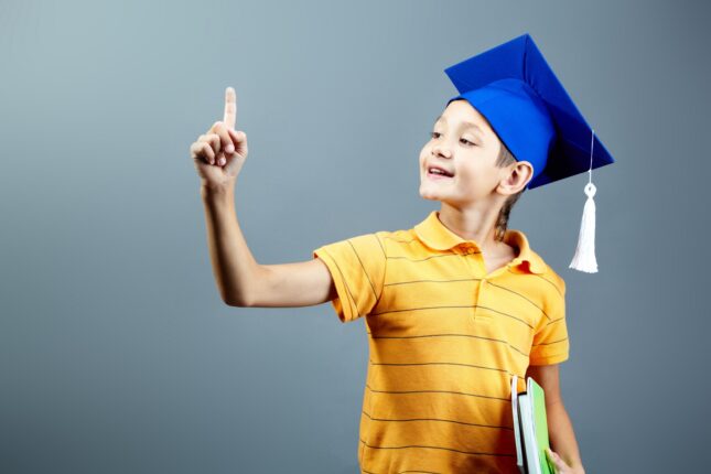 Un petit enfant portant une casquette de graduation bleue.