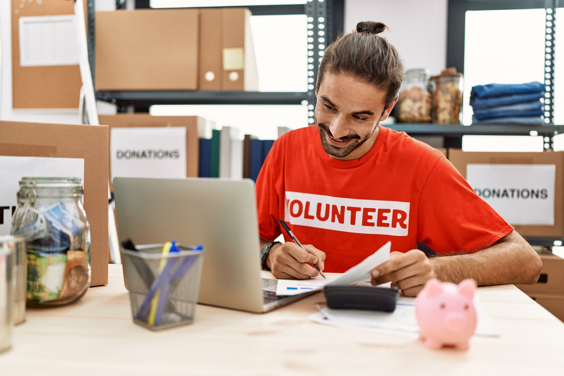 homme travaillant comme bénévole faisant a comptabilité au stand de don