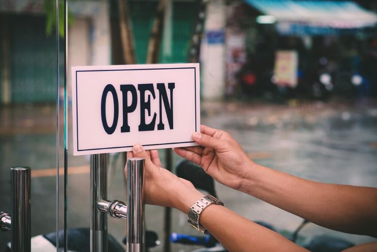 les mains tenant une pancarte OPEN
