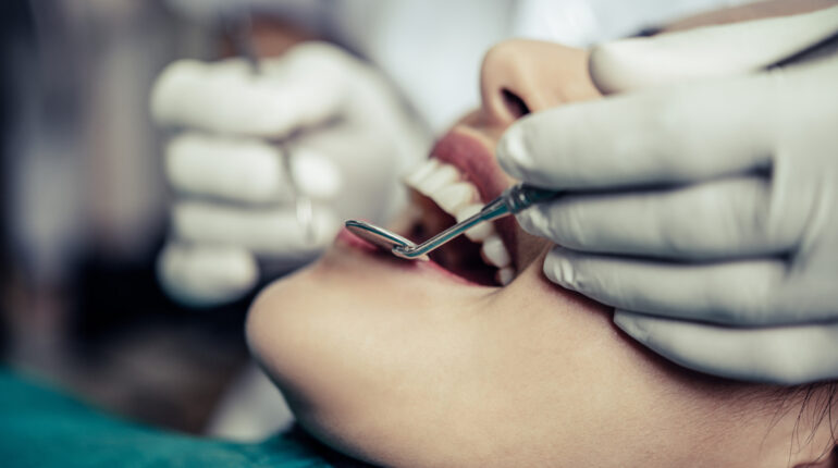 Le dentiste traite les dents du patient.