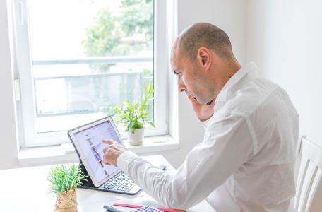 un homme analysant des données sur tablette